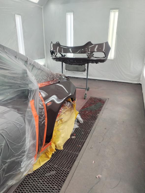 Automaalaamo M. Laitisen maalauskammio, jossa auton puskuri ja kylkipaneeli maalauksessa laadukkaalla automaalilla.