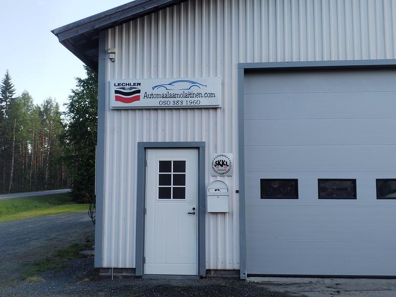 Automaalaamo ja peltikorjaamo M. Laitisen rakennuksen etuovi ja kyltti, jossa yrityksen logo ja yhteystiedot.