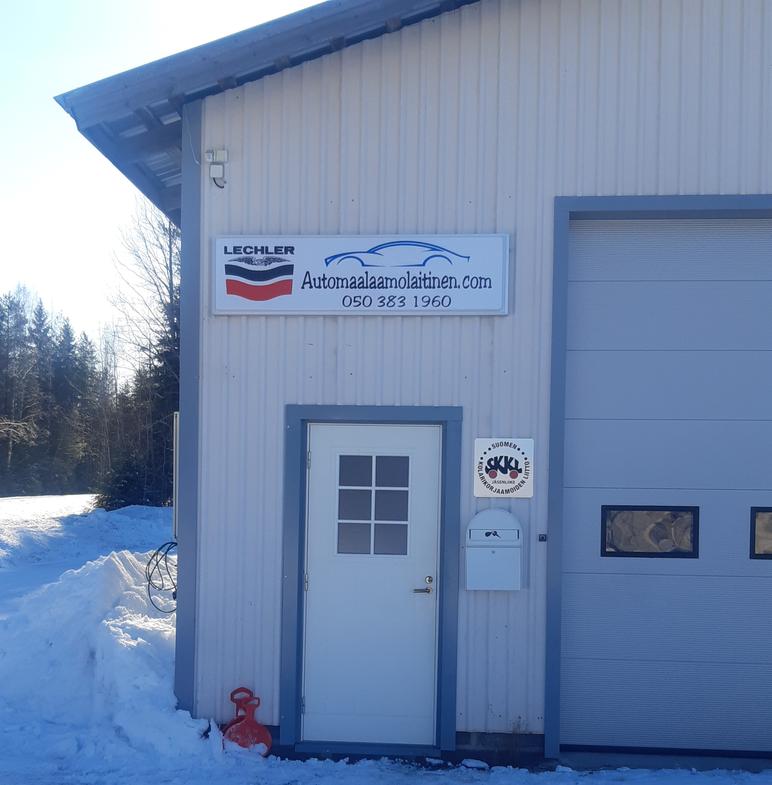 Automaalaamo ja peltikorjaamo M. Laitisen sisäänkäynti talvisena päivänä, kyltti ja yrityksen logo seinällä.